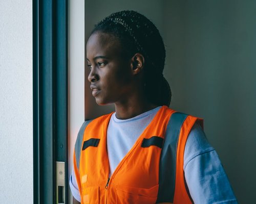A person looking out of a window calmly during work break